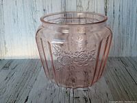 Front view of pink depression glass planter showing embossed rose pattern and fluted panels on sides.