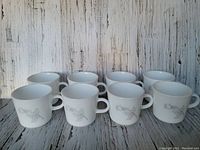 Front view of eight Corning "Solitary Rose" mugs arranged in two rows showing the rose design on each mug