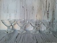 Front view of the four short martini glasses showing the bowl and hobnail textured base details.