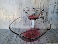 Photo showing the two-tiered chip and dip server with a ruby red tinted large bowl and smaller elevated dip bowl on metal stand.