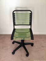 Front view of the green and black bungee cord swivel office chair showing the woven seat and backrest on a black base.