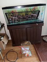 Fish tank on stand with bird cage in front on floor