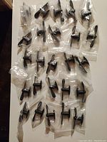 29 individually bagged small fans with dual USB and Lightning connectors and black blades shown in a grid on a surface
