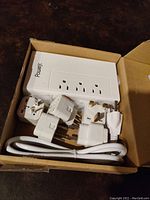 Unopened box containing voltage converter, plug adapters, and extension cord.