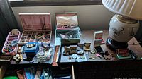 Wide overview of tray, watches, boxes, lamp on tabletop