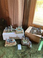 Group photo of five European castle replica models placed on carpet and boxes seen from top and side angles.