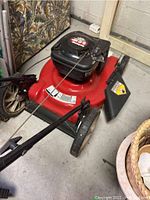 Red MTD Yard Machine gas lawn mower with black engine and side discharge chute