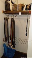 View of handbags placed on a wooden shelf showing various styles including leather and woven bags.