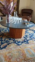 Front view of coffee table showing round stone top and octagonal wooden base.