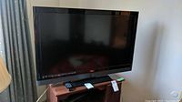 Front view of Vizio 42 inch TV set on wooden stand, screen off