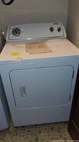 Front view of Whirlpool electric dryer showing control panel with rotary knobs and closed door.