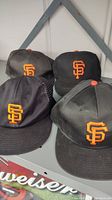 Four black San Francisco Giants hats, showing the front logos and overall condition.