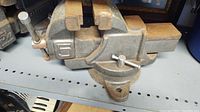 Side angle of heavy duty metal vise with large jaws, showing size and base mounting holes.