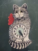Front view of cat-shaped clock showing dial and painted design