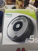 Photo of the iRobot Roomba model 655 in its original box showing front side with product image and details.