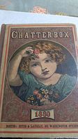 Front cover of the book 'Chatterbox' with an illustrated girl holding a rose, dated 1880, published by Estes & Lauriat in Boston.