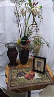 Wide photo showing all items including three vases, artificial flowers, placemat, and framed art