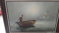 Frontal view of the painting showing the man rowing the boat on calm water towards a lighthouse in fog.