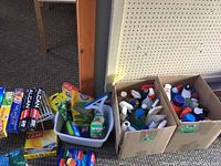 Photo showing boxes of assorted cleaning sprays, metal wire shelf organizers, and some loose cleaning tools.