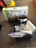 Various Wii accessories including controllers, Wii console, balance board, and game boxes