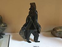 Front three-quarter view of the hunter carving showing hooded figure carrying catch