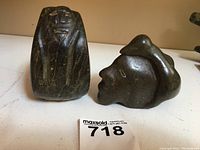 Two soapstone carvings: a circular person and a penguin on an Eskimo figure, showing front of both items and size relative to auction tag.