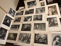 Overall view of all 21 steel engraving prints arranged on a surface, showing black and white images mostly of theatrical scenes and characters from Shakespeare's plays, some prints slightly stacked or overlapping.