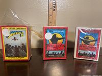 Photo shows three sealed boxed Topps card sets: Superman II 1980 set with 88 cards and 22 stickers, and two Robin Hood Prince of Thieves 1991 sets each with 55 cards and 9 stickers. All boxes have intact shrink wrap but show some yellowing and wear from age.