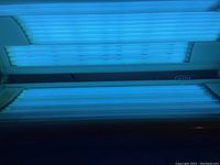 Close up of bottom UV bulbs lit inside the tanning bed