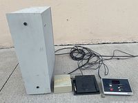 Full view of main dictation unit, smaller components, and connected cords shown on a ground surface