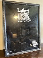 Full view of Labatt Ice Beer sign with visible cracks on the glass and wood frame wear.