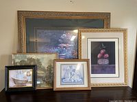Full view of all five framed artwork pieces arranged on a surface showcasing their relative sizes and frame styles.