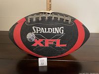 Front view of Spalding XFL football showing logos, condition and color pattern.