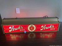 Front view of illuminated Stroh's Beer pool table light showing bright lighting and logo.
