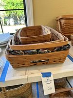 Photo of three nested Longaberger baskets, largest with floral liner visible.