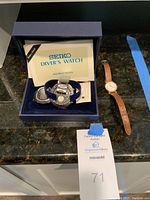 Box containing Seiko instruction manual, diver’s watch and separate Pulsar watch on countertop