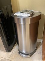 Aluminum Simplehuman step trash can closed showing pedal and lid
