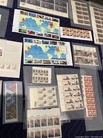 Multiple US commemorative and definitive stamp sheets laid out, including Legends of the West and Turning the Tide