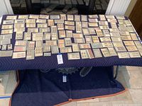 Table surface covered with dozens of protective mounts holding U.S. stamp blocks, pairs and singles.