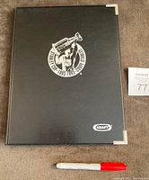 Black hardcover Kraft binder with metallic corners and embossed Stanley Cup 1893-1993 logo and Kraft logo on the front cover, placed next to a marker for scale.