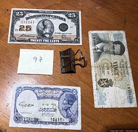 Photo showing 1923 Bank of Canada 25 cent shinplaster note, a Belgium 20 Franc note, and a United Arab Republic note with a binder clip for scale.