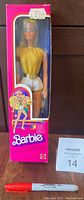 Front view of Barbie doll in original pink box with gold top and silver shorts, includes price sticker and MaxSold auction label.