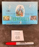 Photo showing front of factory sealed blue box of FernGully trading cards with promotional art and Dart branding, alongside a red Sharpie marker for scale.