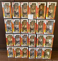 Front view of 24 bobblehead boxes arranged in rows, showing colorful packaging with Canada hockey logos and player figures visible.