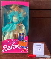 Barbie doll in original box, front view showing the doll with blue sheer dress and pink box with original packaging and stickers.