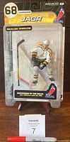Front of unopened original packaging showing Jaromir Jagr figurine in white and gold hockey uniform with stick and base.