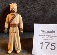 Front view of vintage 1977 Star Wars Sand People Tusken Raider figure standing upright showing sculpted head details, cream color body with brown gloves and belts.
