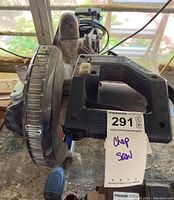 Top front view of the chop saw showing handle and protective blade cover with MaxSold tag attached