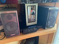 Photo of entire stereo system setup showing main unit, two speakers, and remote control on table.