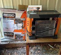 Overview of Ridgid thickness planer next to its original boxes